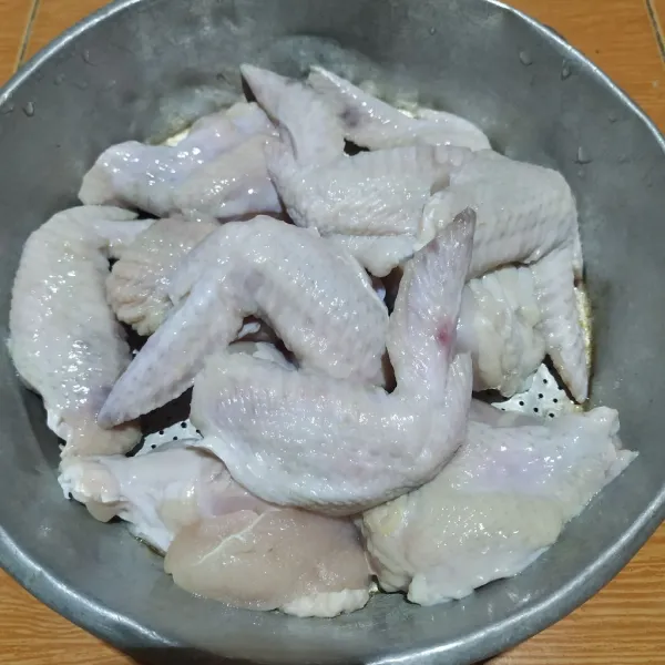 Potong sayap ayam menjadi 2 bagian, cuci bersih. Lumuri dengan air jeruk nipis dan diamkan selama 15 menit, bilas kembali.