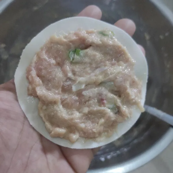 Ambil 1 lembar kulit dimsum dan 1 sdm adonan dimsum kemudin ratakan dan lipat setiap sisinya.