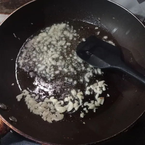 Tumis bawang putih cincang sampai matang.