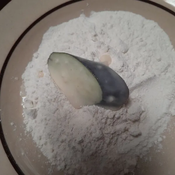 Gulingkan terong ke dalam tepung basah.