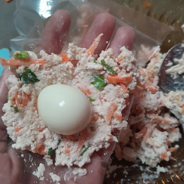 Ambil satu sendok makan adonan lalu tambahkan telur puyuh lalu bulatkan.