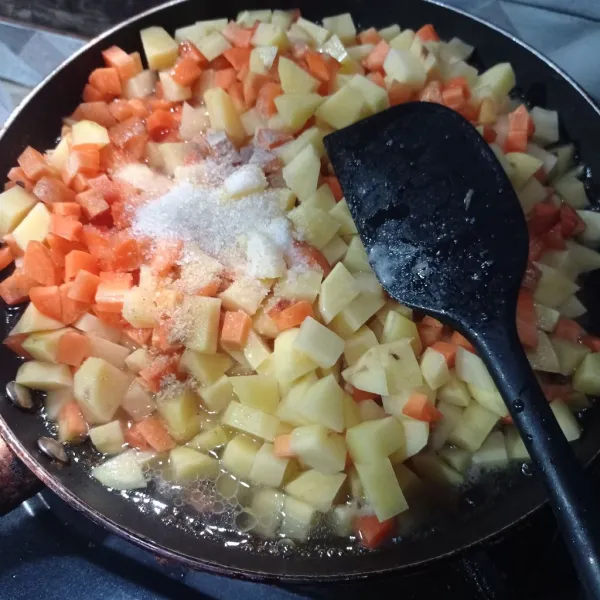Masukkan kentang, wortel, garam, lada bubuk, kaldu bubuk dan gula pasir, aduk rata.