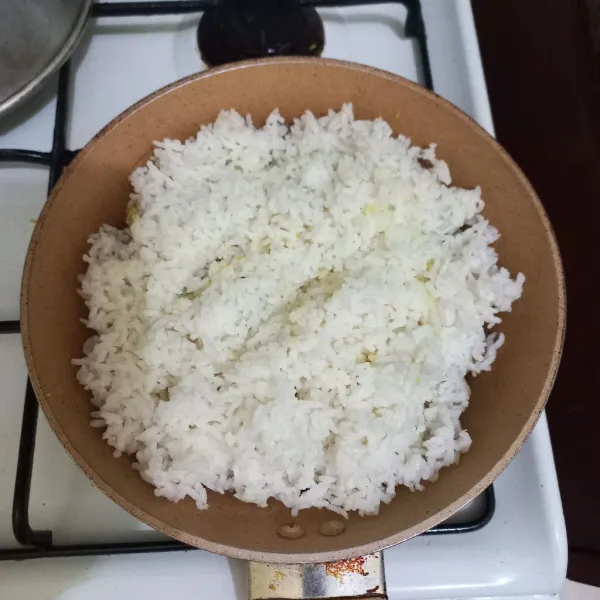 Masukkan nasi pada wajan, aduk rata.