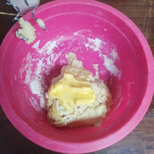 Masukkan garam dan margarin, mikser lagi sampai adonan kalis elastis.