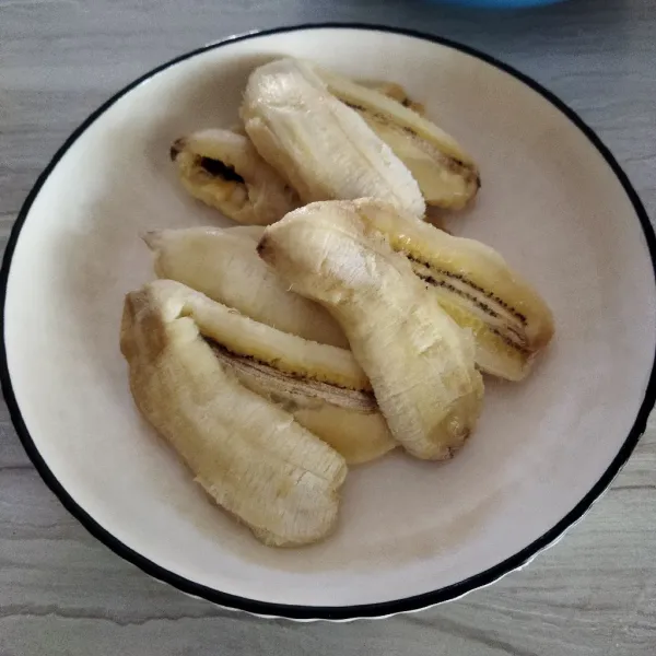 Belah pisang menjadi 2 bagian tapi jangan terputus.