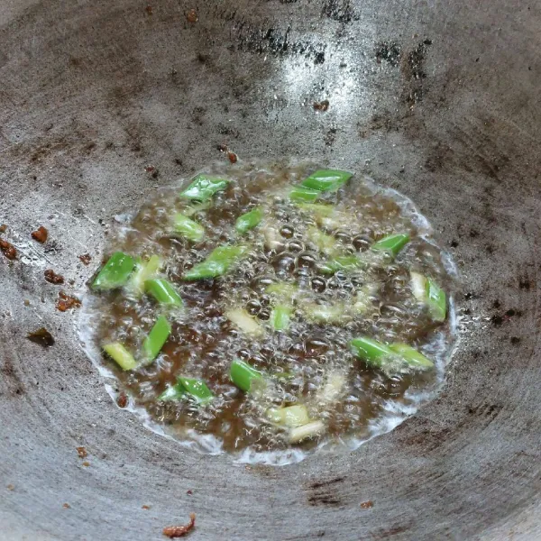 Panaskan minyak goreng, lalu goreng daun bawang prei sampai layu.