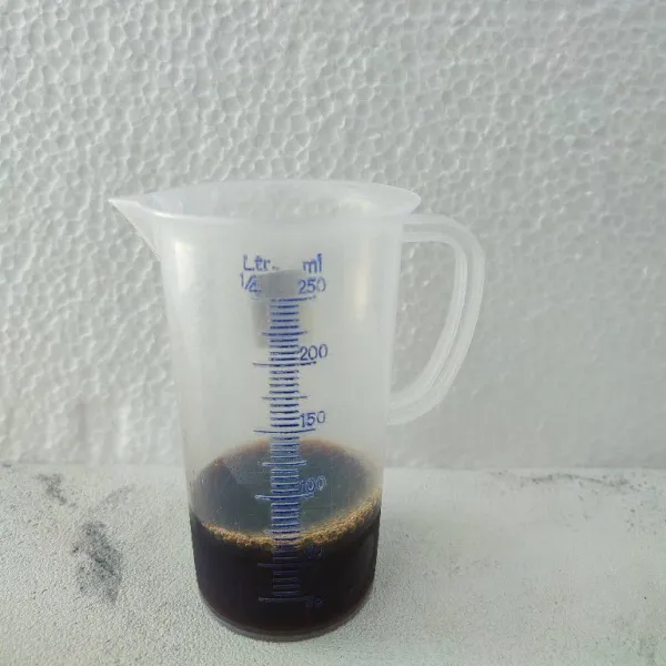 Seduh kopi bubuk tanpa ampas dengan air panas lalu biarkan hingga hangat.