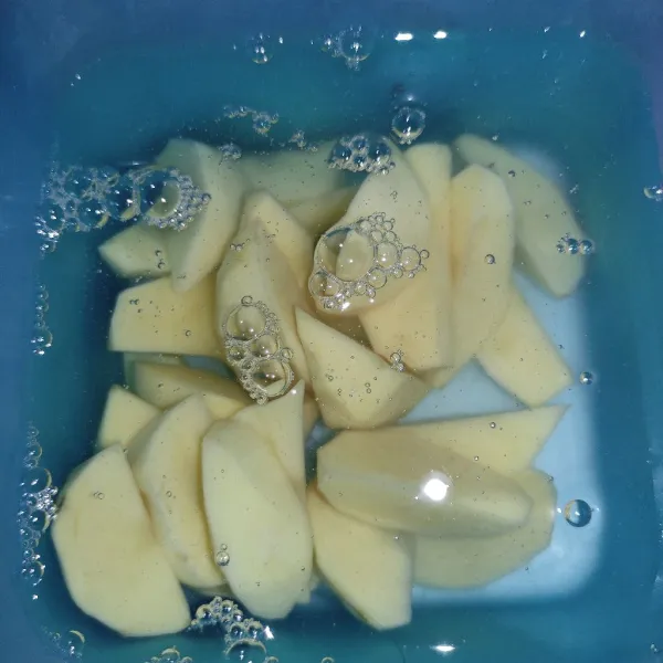 Potong kentang, lalu rendam di dalam air garam.