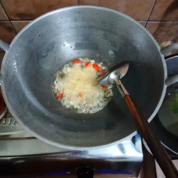 Tumis bawang merah, bawang putih dan cabai rawit merah hingga harum dan layu.