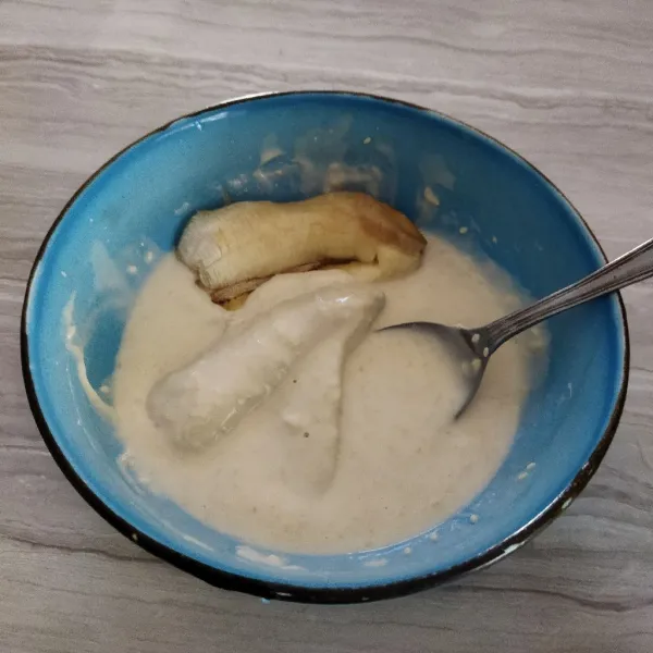 Celupkan pisang dalam adonan balur hingga semua pisang terlapisi adonan.