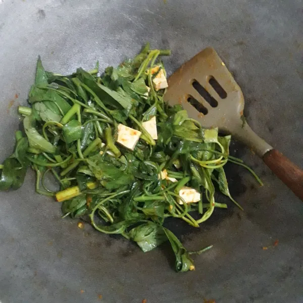 Masukkan kangkung dan tahu, aduk-aduk sampai kangkung agak layu.