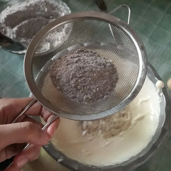 Masukkan campuran tepung kedalam adonan sambil diayak. Campurkan sedikit demi sedikit sambil diaduk balik.