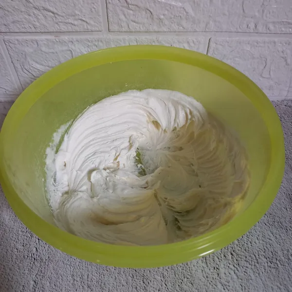Mixer whipped cream bubuk dan air es sampai mengembang.