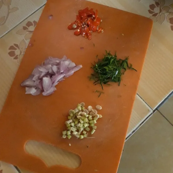 Iris tipis bawang merah, cabe rawit merah, sereh, dan daun jeruk. Masukkan ke dalam mangkuk tahan panas.