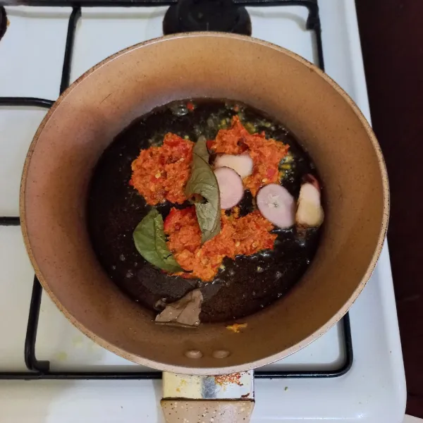 Tumis bumbu halus beserta lengkuas dan daun salam hingga harum.