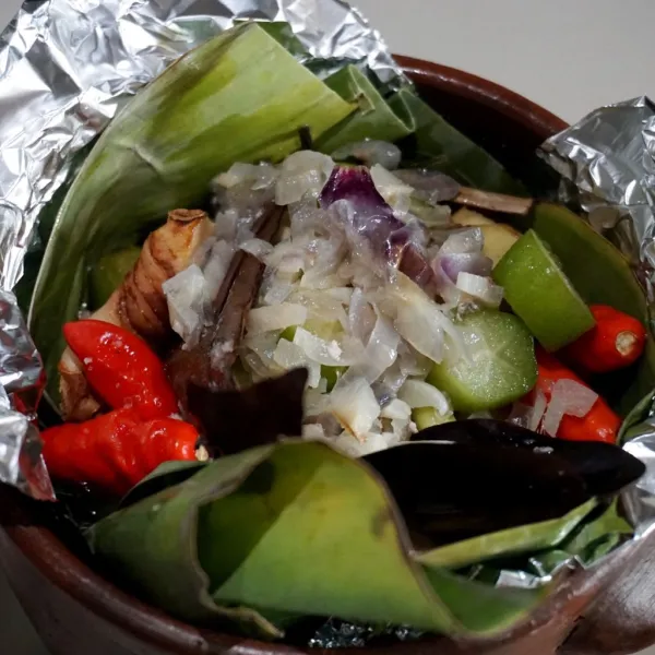Masukkan ayam yang telah ditumis ke dalam mangkuk yang dilapisi daun pisang & alumunium foil, lalu tambahkan irisan bahan-bahan utama lainnya.