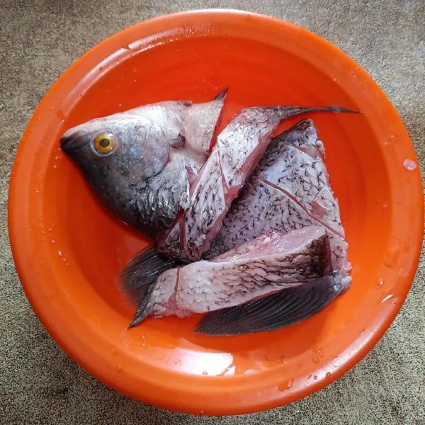 Cuci ikan gurame hingga bersih, lalu potong jadi empat bagian.