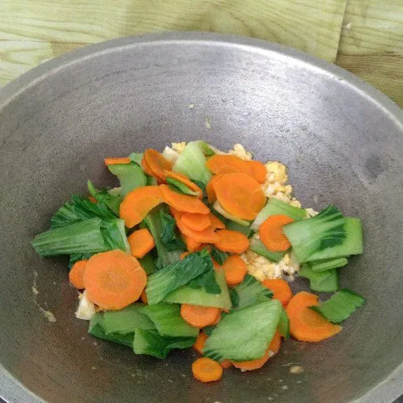 Masukkan air, wortel, batang pakcoy dan masak sampai setengah empuk.