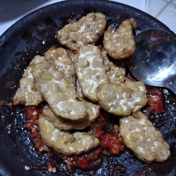 Campur tempe dengan bumbu ulek sambil sedikit dibejek, aduk hingga rata.