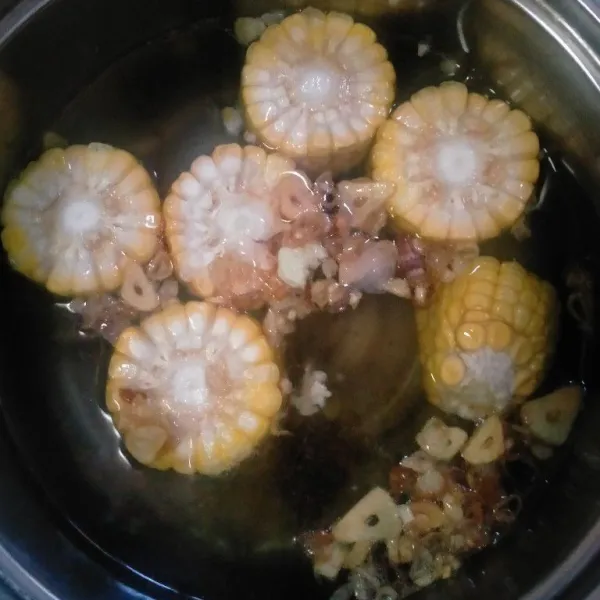 Masukkan potongan jagung, bawang yang sudah digoreng dan kencur. Masak hingga jagung matang.