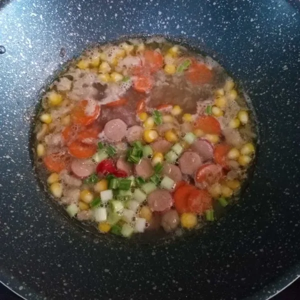 Masukkan sosis dan daun bawang, masak hingga matang.