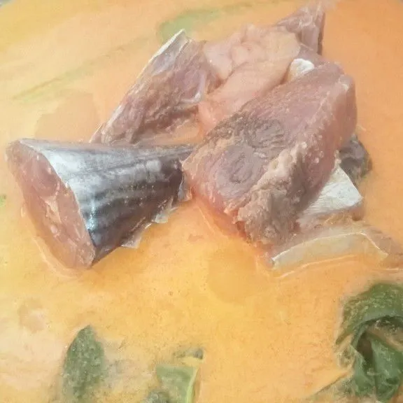 Setelah santan mendidih masukkan ikan, aduk rata.