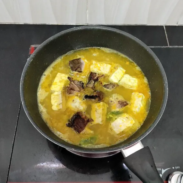 Kemudian masukkan tempe dan ikan manyung asap. Masak hingga mendidih kembali.