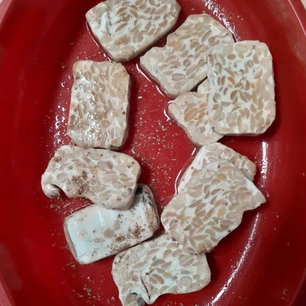 Potong tempe, lalu marinasi dengan garam, ketumbar, dan kaldu bubuk.