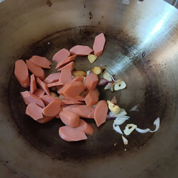 Masukkan sosis. Tumis hingga matang dan berkulit.