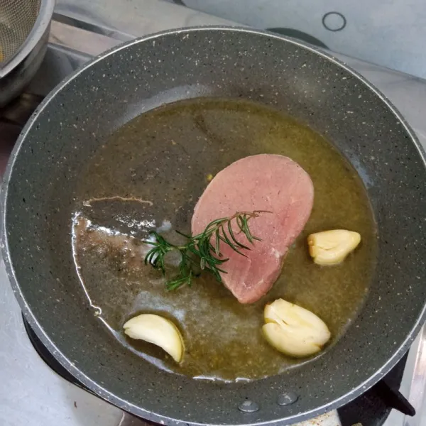 Panaskan minyak goreng. Masukkan daging, bawang putih dan rosemary. Kemudian masukkan margarin panggang sampai matang. Jangan lupa dibalik.