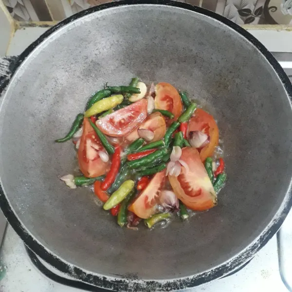 Panaskan minyak goreng dalam wajan. Masukkan bahan sambel. Goreng setengah matang.
