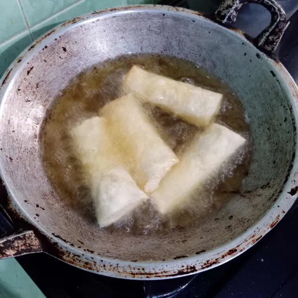 Goreng lumpia tahu hingga matang.