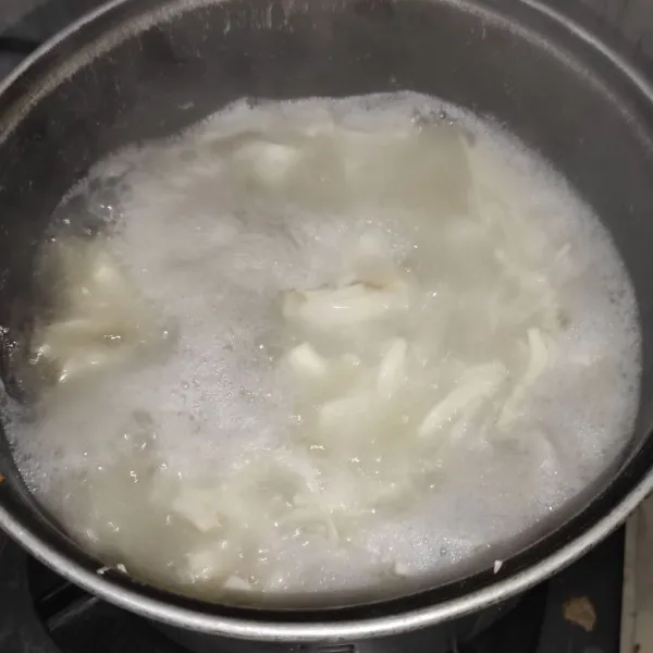 Rebus umbut kelapa setengah matang. Matikan kompor begitu air mendidih. Tiriskan air. Tips: umbut kelapa yang baru di rebus harus langsung dimasak. Tidak boleh di simpan di kulkas karna akan membuat rasa berbeda.