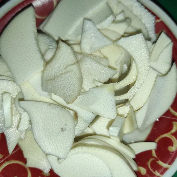 Potong-potong umbut kelapa. Tips: siapkan baskom berisi air saat akan memotong umbut kelapa. Langsung rendam dalam air begitu selesai memotong. Karna jika di diamkan sebentar akan berubah warna menjadi merah.
