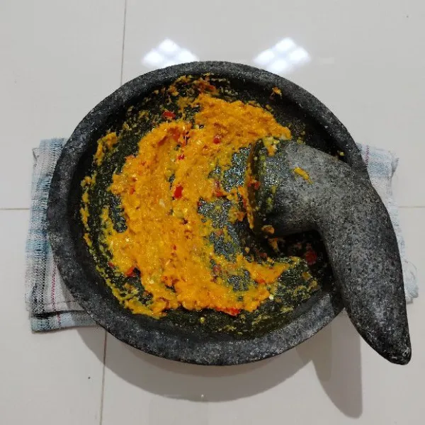 Masukkan bahan bumbu ke dalam cobek. Lalu haluskan.