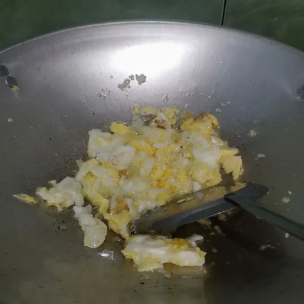 Pecahkan telur di atas wajan lalu orak-arik hingga setengah matang.