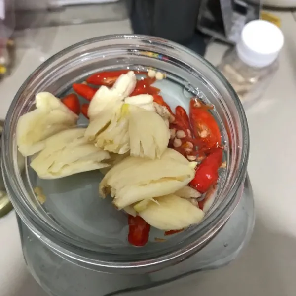 Setelah air garam benar-benar dingin, susun telur bebek mentah dalam wadah kaca atau plastik, lalu tuang air garam dan terakhir masukkan irisan cabai dan bawang putih geprek. Aduk sebentar agar bawang putih dan cabe merata.