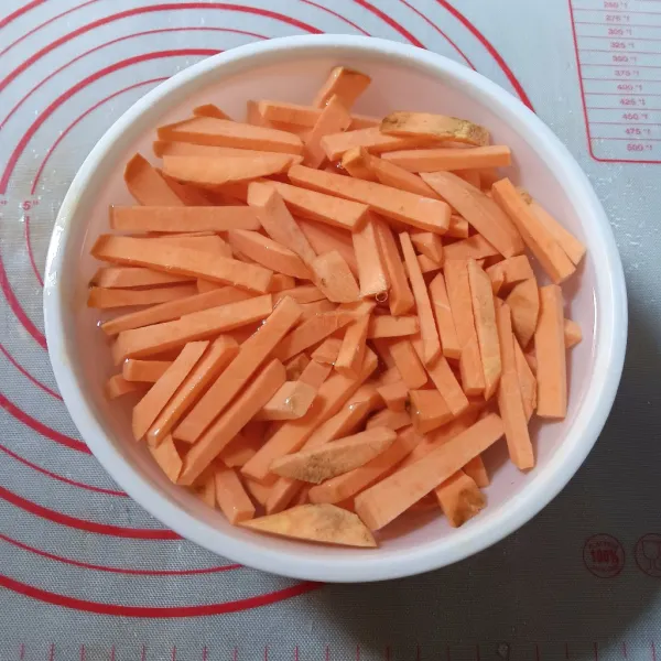 Kupas ubi dan cuci bersih. Potong setebal 1 cm kemudian potong memanjang. Rendam air agar tidak menghitam.