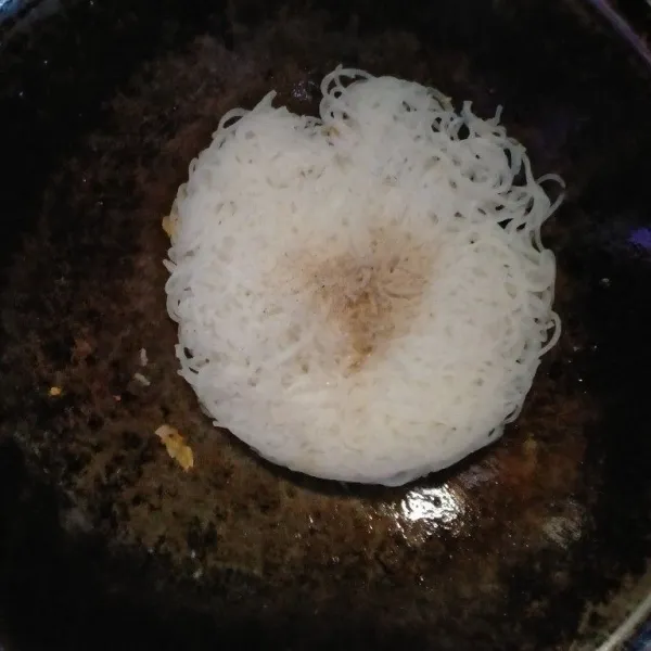 Masukkan bihun. Tambahkan garam, kaldu bubuk, dan lada bubuk. Aduk hingga bihun tercampur dengan bumbu.