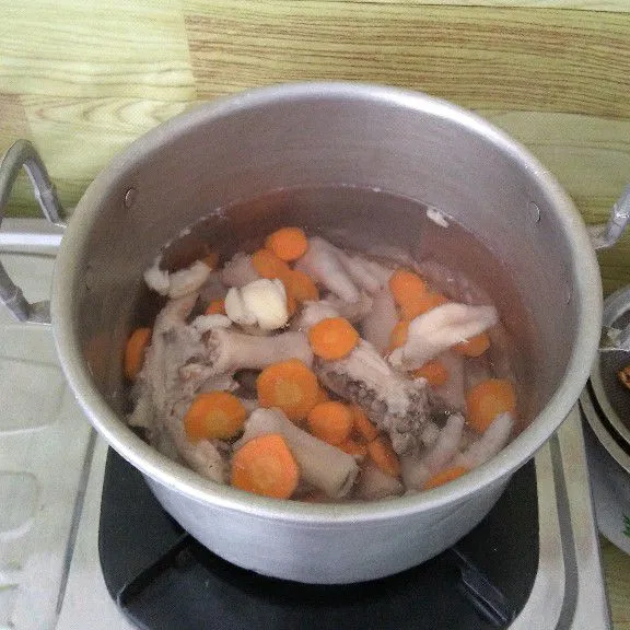 Masukkan wortel dan ceker ayam. Masak hingga wortel setengah matang.