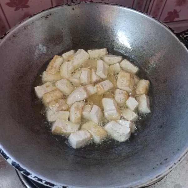 Potong dadu tahu kemudian goreng hingga setengah matang, setelah itu angkat dan tiriskan.