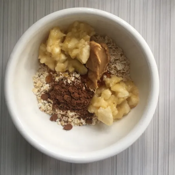 Masukkan oatmeal, setengah bagian pisang yang sudah dilumatkan, coklat bubuk, selai kacang dan madu.