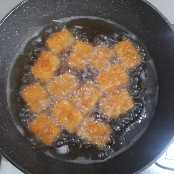 Panaskan minyak goreng dalam wajan. Masukkan nugget, goreng sampai kering. Balik saat bagian bawah sudah kering. Angkat dan tiriskan.