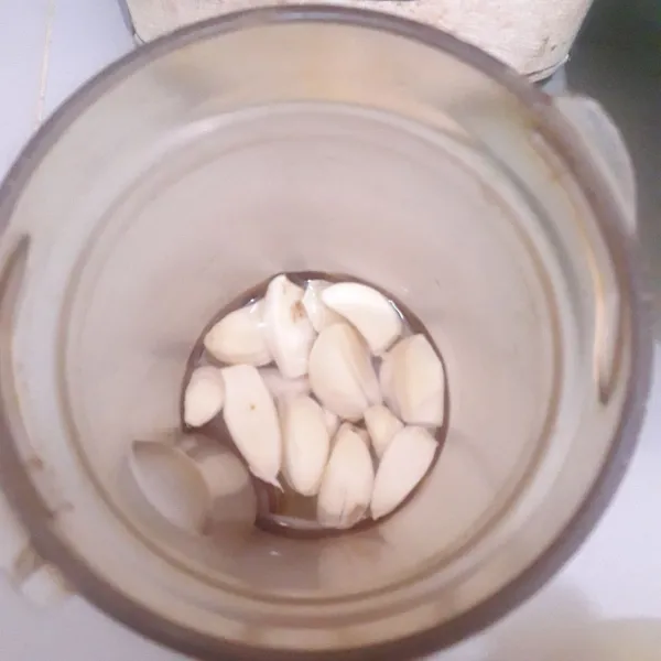 Siapkan blender.Masukkan bawang putih ke dalam blender. Beri sedikit air. Blender sampai halus.