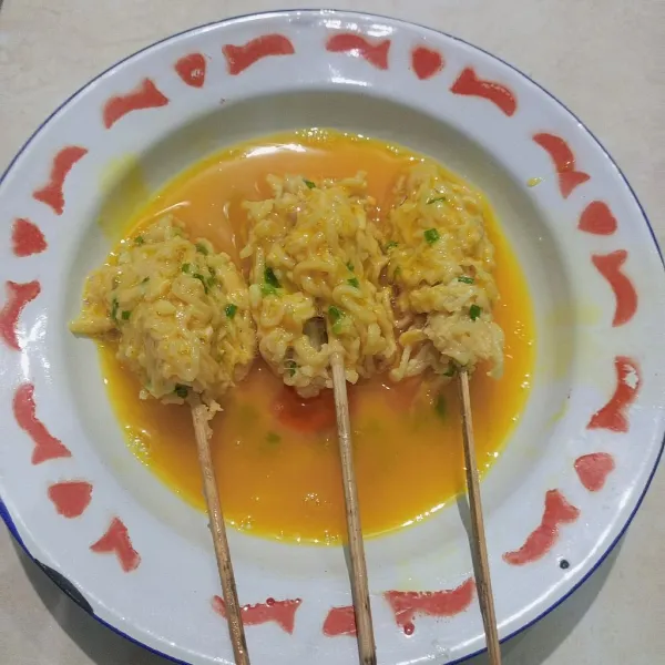 Kocok 1 telur beri sejumput garam, lalu balurkan sempol mie ke dalam telur.