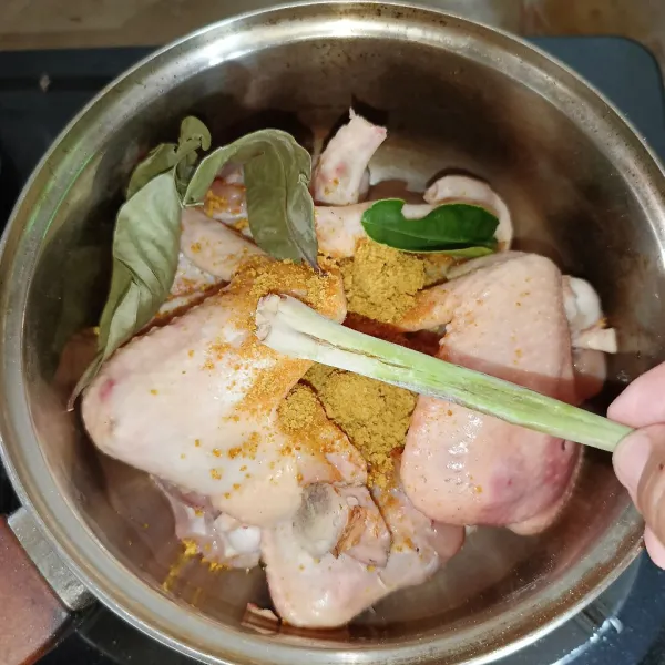 Tambahkan bumbu ungkep ayam, serai, lengkuas, daun salam dan daun jeruk.