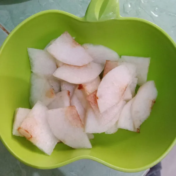 Kupas dan iris-iris buah pear.