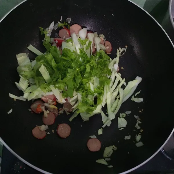 Masukkan irisan selada dan daun bawang lalu tumis hingga layu.