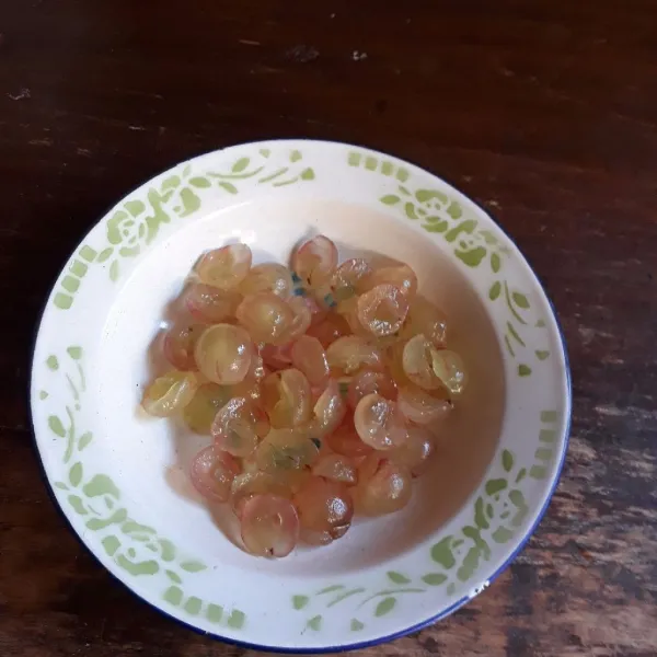 Kupas kulit anggur, belah 2 dan buang bijinya.