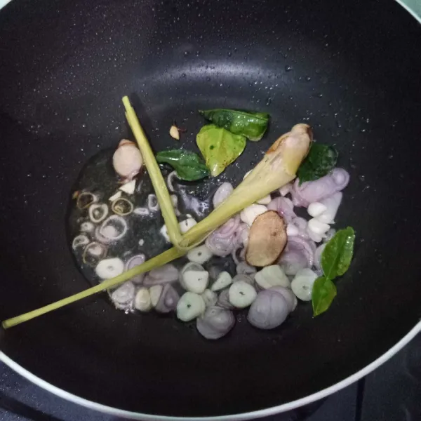 Panaskan minyak, tumis serai, daun jeruk, lengkuas, bawang merah dan bawang putih sampai harum.